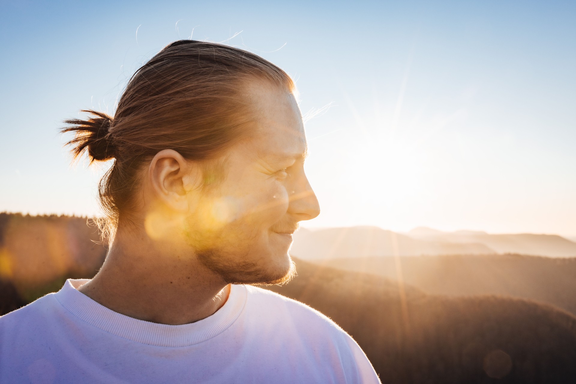 Jeune homme souriant regardant dans le coucher du soleil Portrait de la génération du millénaire